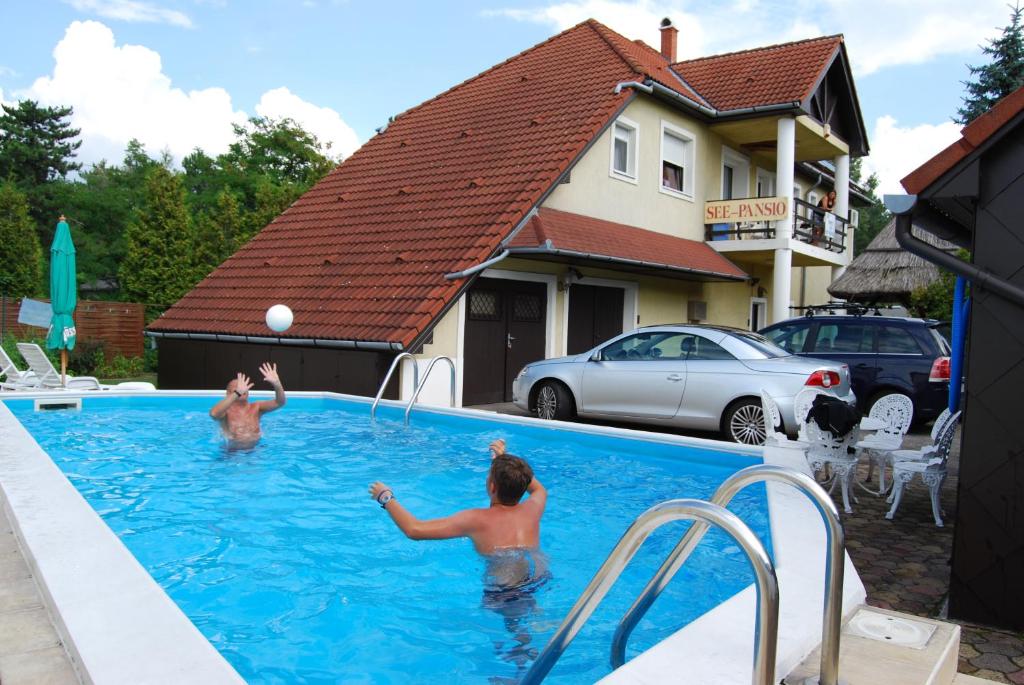 dos personas jugando con una pelota en una piscina en See Vendégház - Siófok en Siófok