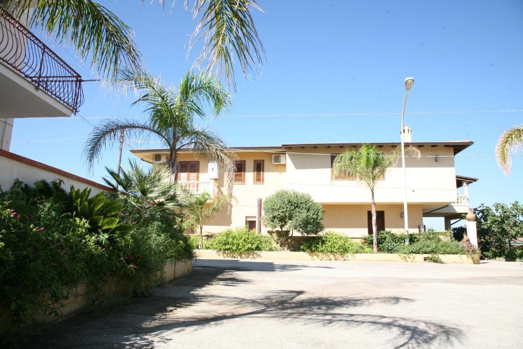 ein Gebäude mit Palmen davor in der Unterkunft Residence Marino in Balestrate
