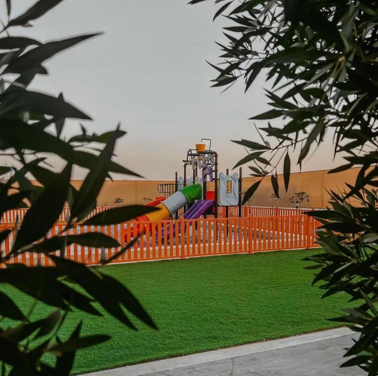 un parque infantil con un tobogán frente a un edificio en Hideout Farmhouse - By Seven Elements en Ras al-Khaimah