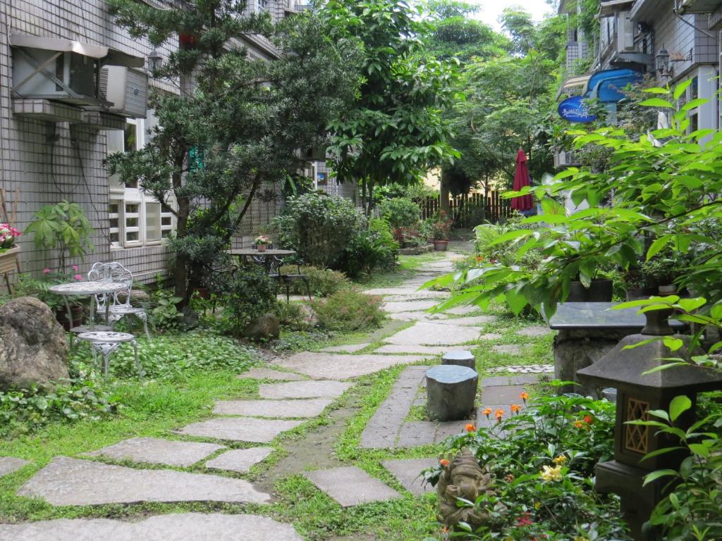 a walkway through a garden with tables and benches at Dongshan River Left Bank in Wujie