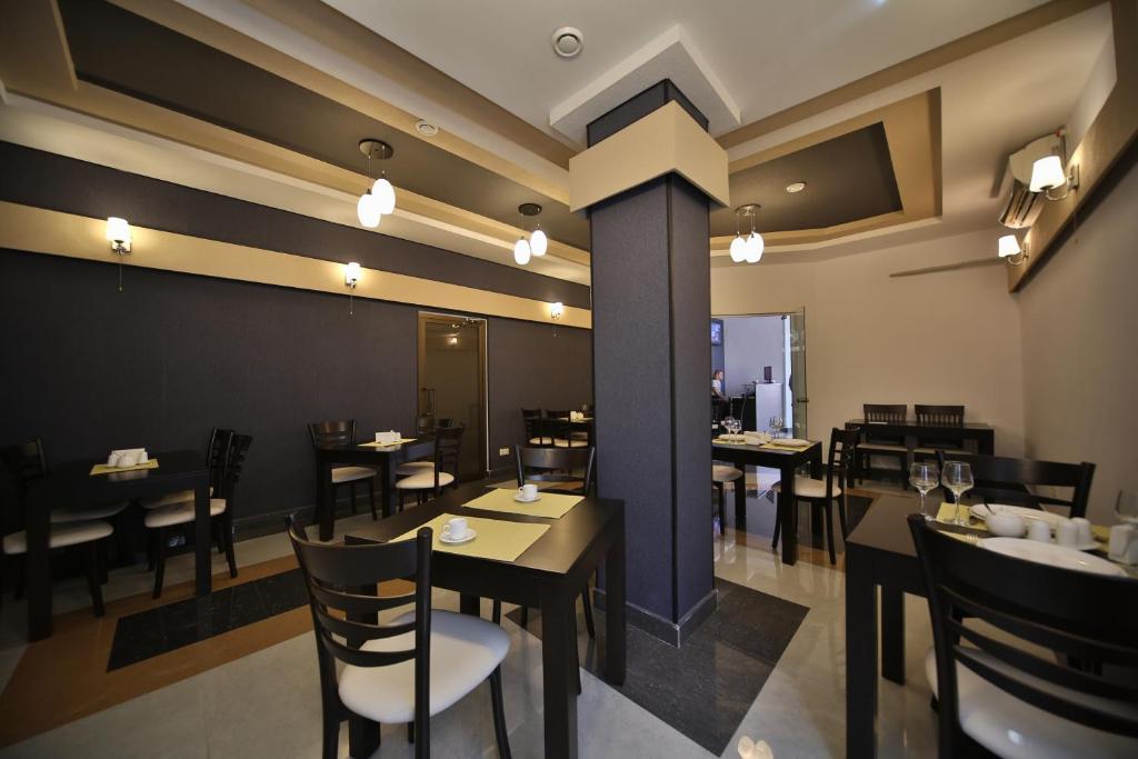 una sala da pranzo con tavoli e sedie in un ristorante di Continental Hotel a Kutaisi