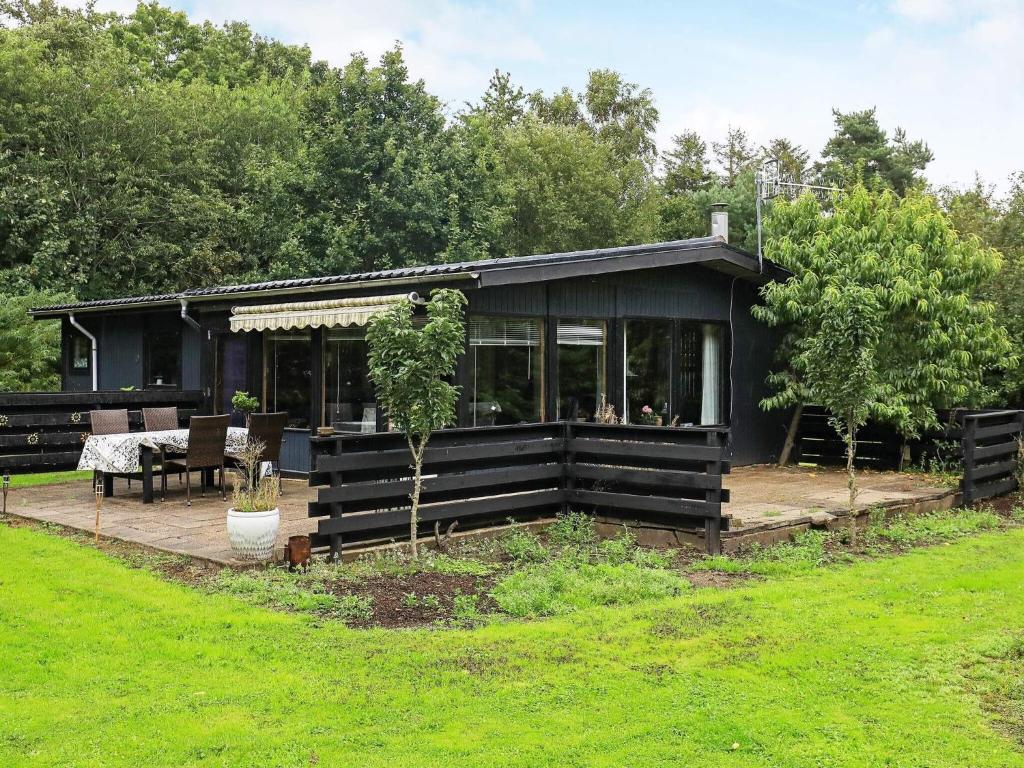 a black house with a patio and a table at Holiday home Roslev IX in Roslev