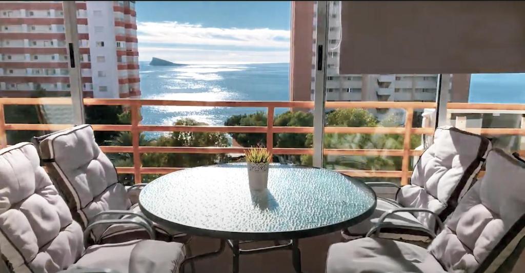una mesa y sillas en un balcón con vistas al océano en Provima B, en Benidorm