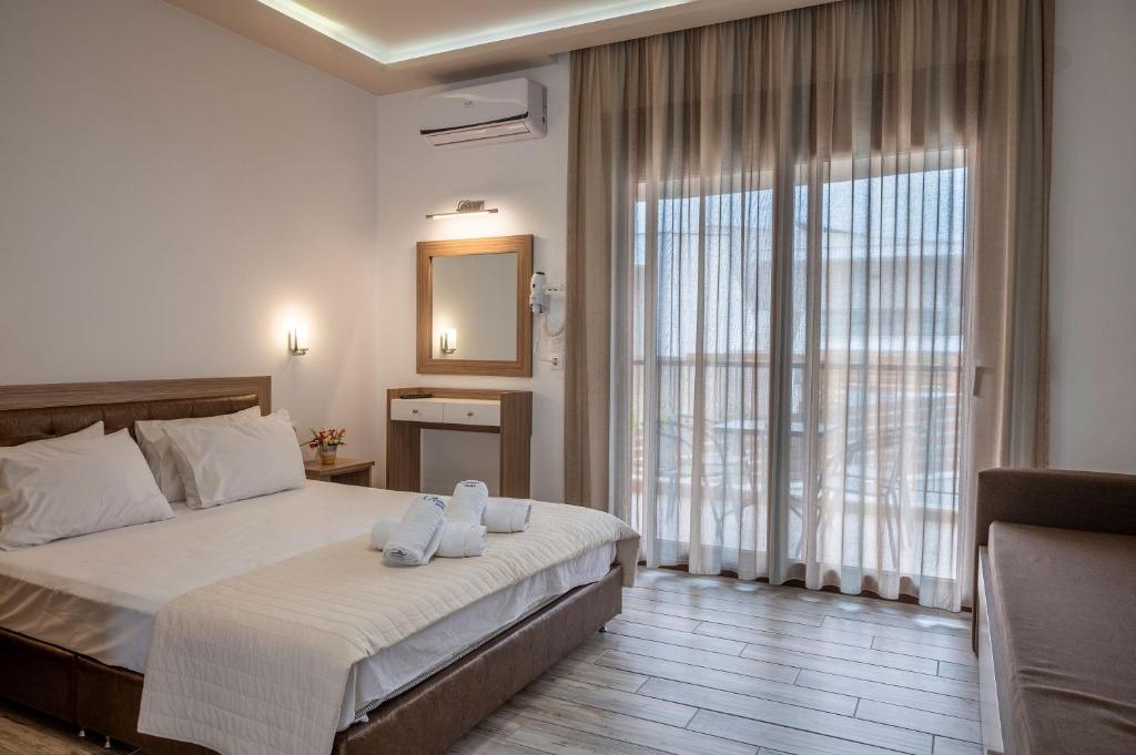 a bedroom with a bed and a large window at Anastasia&#39;s Studios in Polykhrono