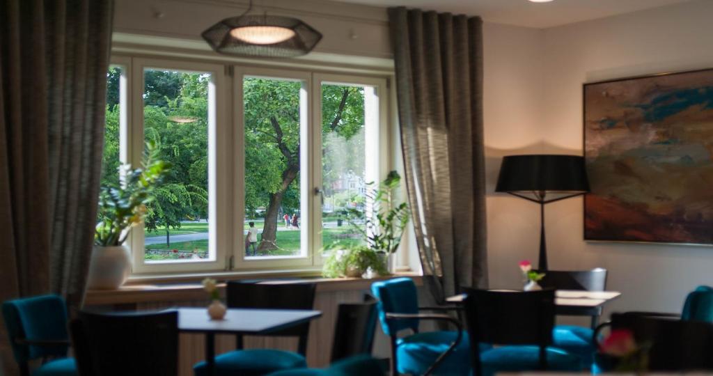 Cette chambre dispose d'une grande fenêtre avec des chaises et une table. dans l'établissement Urban Boutique Hotel Center, à Ljubljana