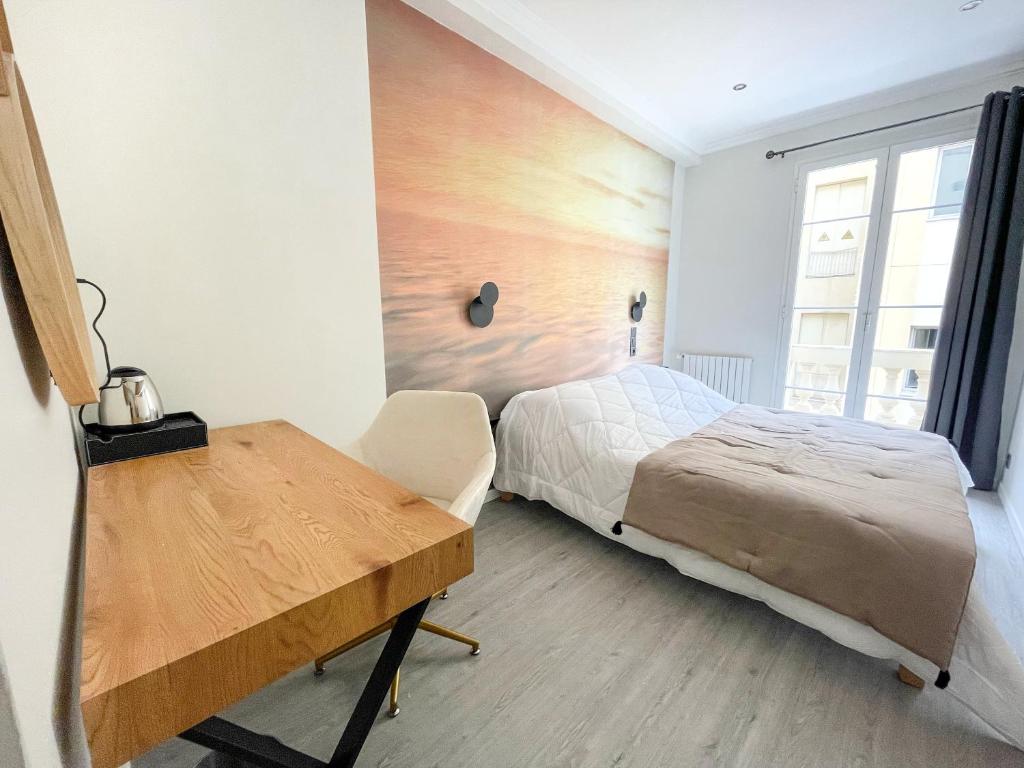 a bedroom with a bed and a wooden desk at Villa Berlioz in Nice
