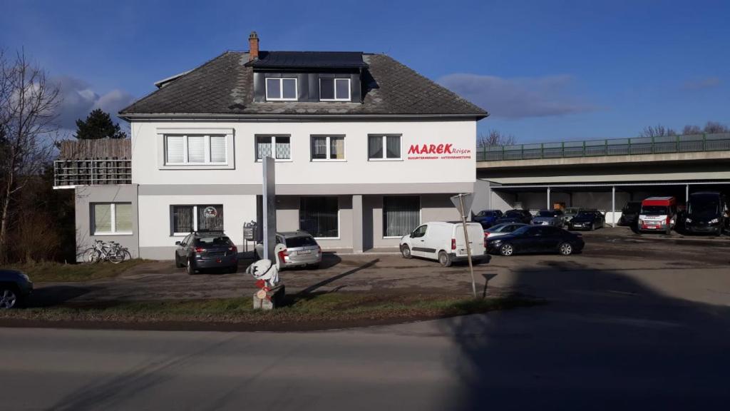 un edificio blanco con coches estacionados en un estacionamiento en Ferienwohnungen Marek, en Ravelsbach