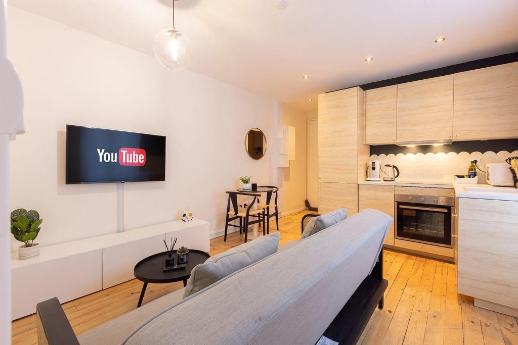 uma cozinha e uma sala de estar com uma televisão na parede em HIMA, Beau T2 rénové à neuf Châteaucreux Gare em Saint-Étienne