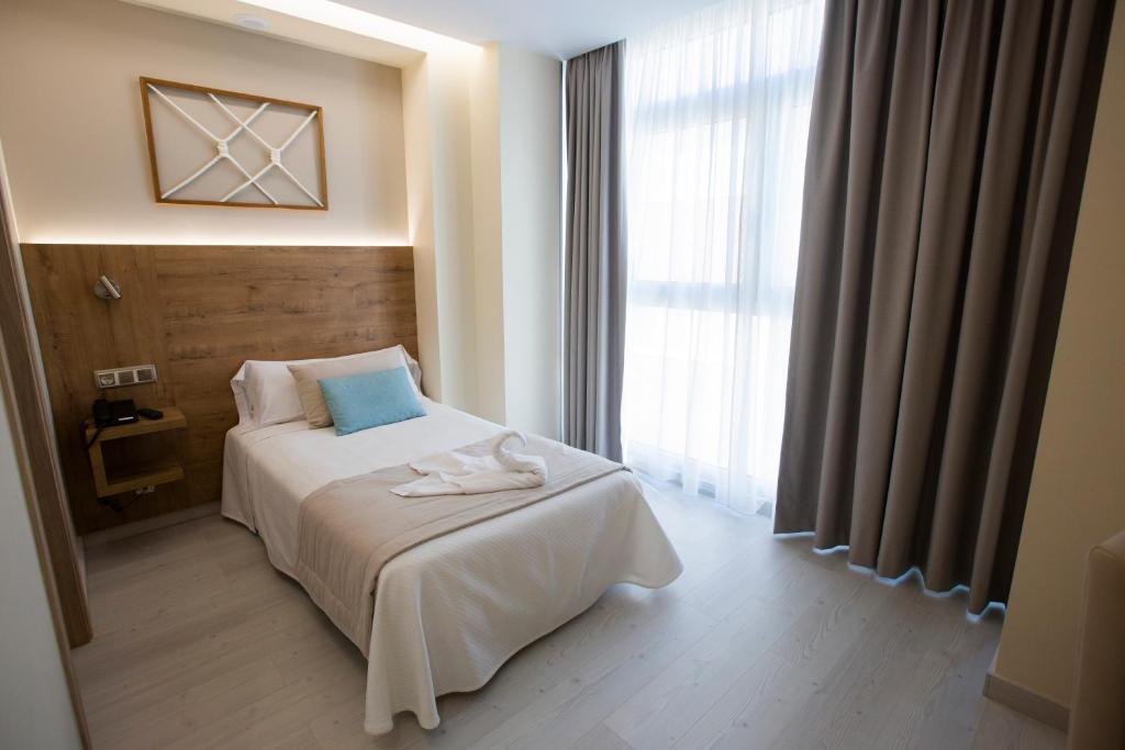 A bed or beds in a room at Hotel Boutique O Náutico Laxe