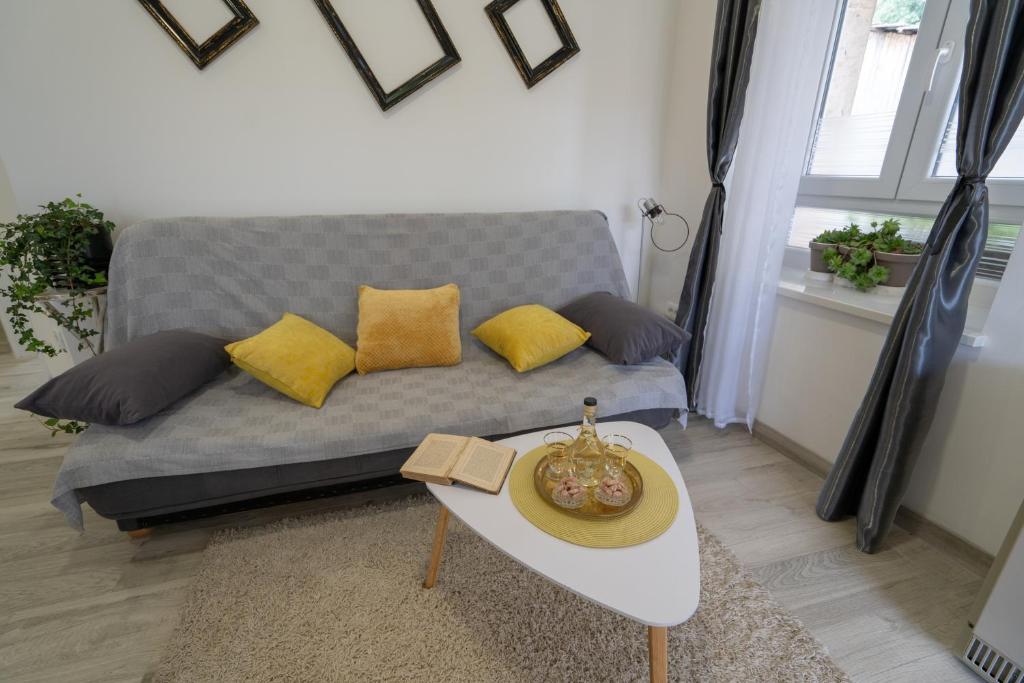 a living room with a couch with yellow pillows at Apartman TONKOVIĆ in Imotski