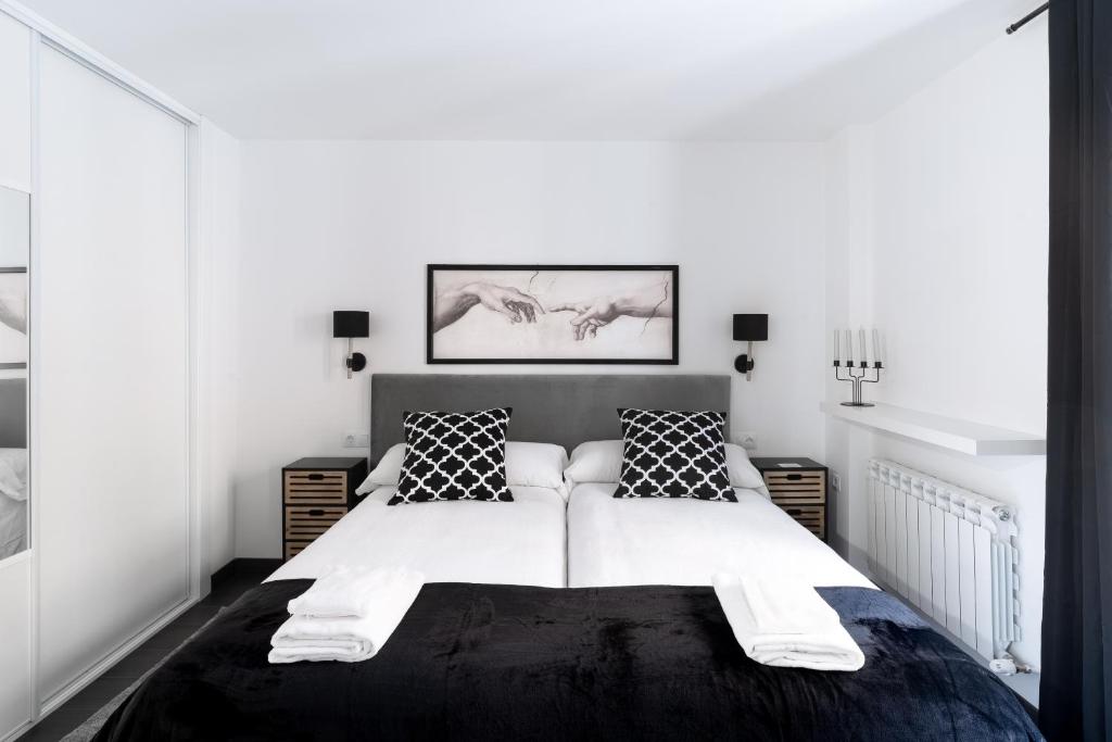 a black and white bedroom with a large bed at Housingleón - Five Rooms in León