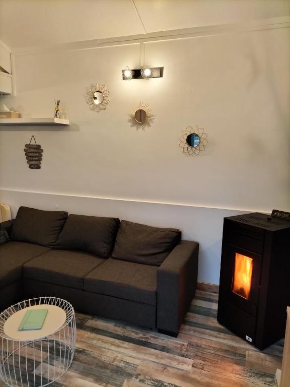 a living room with a couch and a wood stove at Au bord du lac in Royère-de-Vassivière