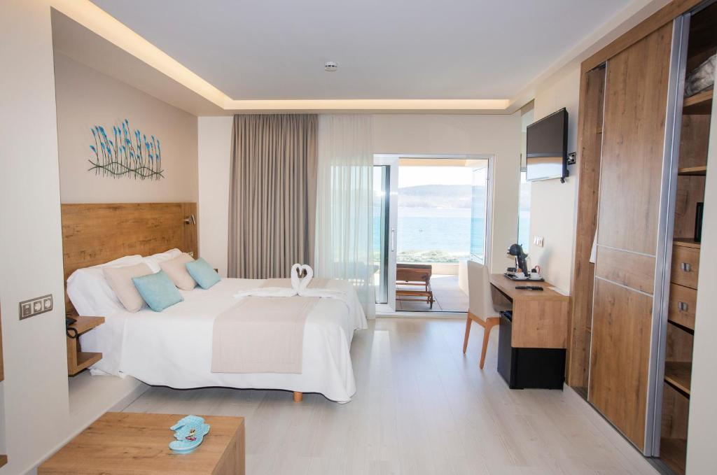 A bed or beds in a room at Hotel Boutique O Náutico Laxe
