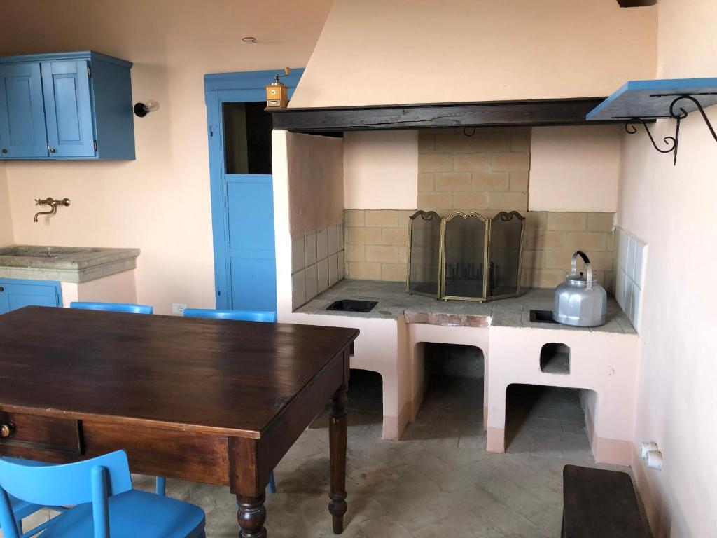 - une cuisine avec une table en bois et une cuisinière dans l'établissement Podere Soccorso casa vigneto, à Montalcino