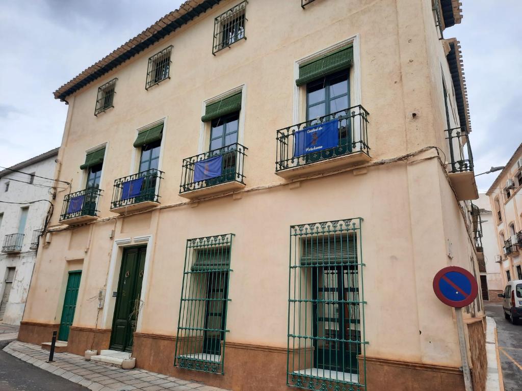 a building with barred windows on a street at Pension Jean Franco room Dylano in Purchena
