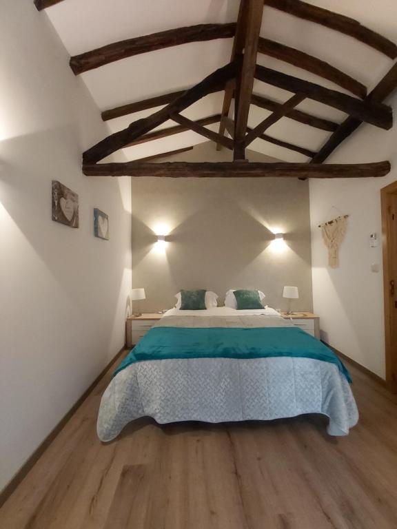 a bedroom with a large bed and a wooden floor at Casa do Jornaleiro - Douro - Quinta da Cabrida in Casal de Loivos