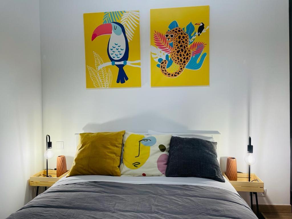 sypialnia z dwoma obrazami na ścianie i łóżkiem w obiekcie Casa das Férias w Lizbonie