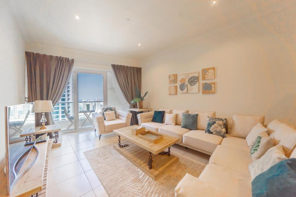 - un salon avec un canapé et une table dans l'établissement HiGuests - Spacious Apartment next to Dubai Harbour & Marina, à Dubaï