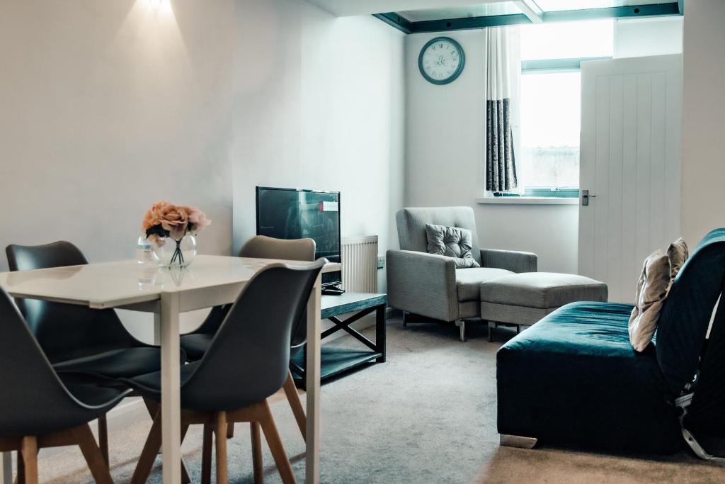 a living room with a table and chairs at Apartments-DealHouse in Huddersfield