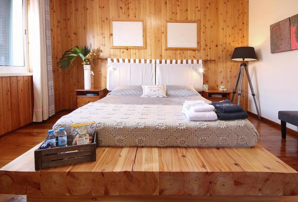 1 dormitorio con 1 cama grande y paredes de madera en Casa da Flor, en Ribeira Grande