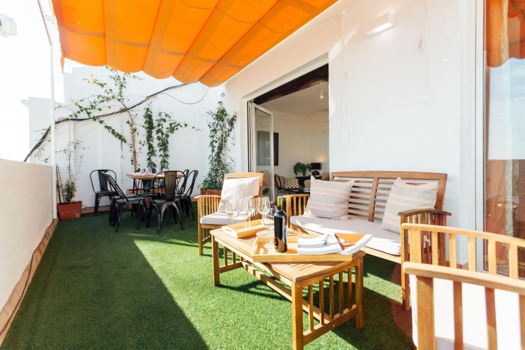 taras ze stołem, krzesłami i kanapą w obiekcie MintyStay - La Campana w Sewilli