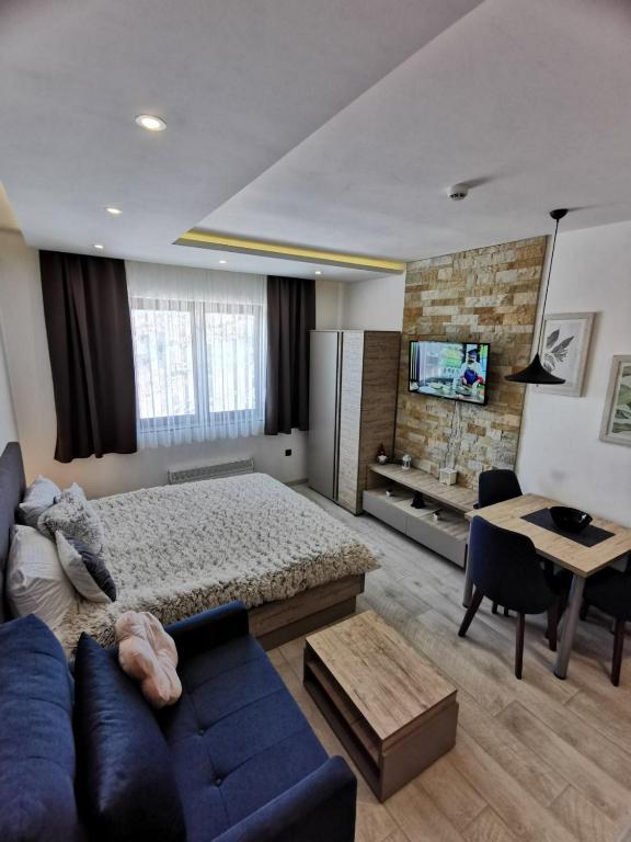 a bedroom with a bed and a blue couch at Šilja Kopaonik S45 Milmari in Kopaonik