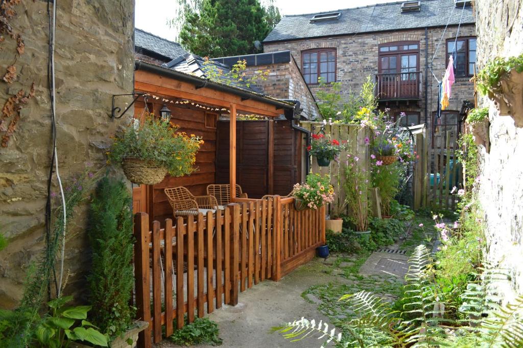 a garden with a wooden fence and a house at Spacious ground floor apartment. No 1A The Stables in Llanfyllin