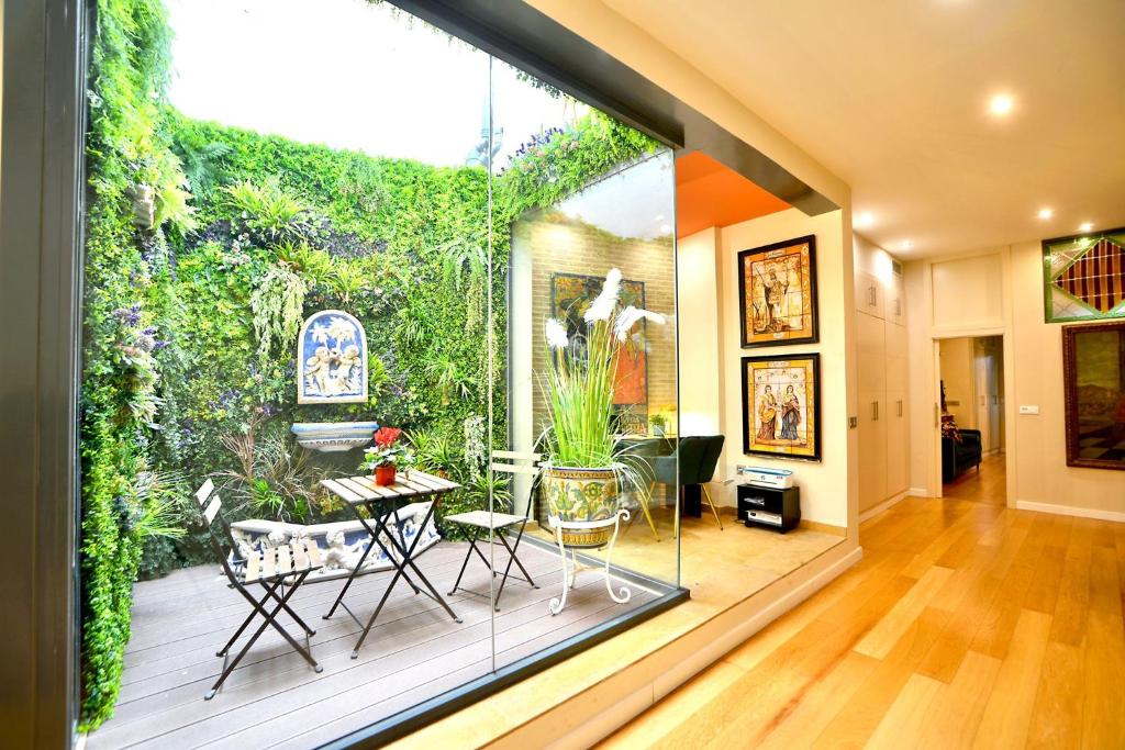 um jardim interior com uma mesa e cadeiras num quarto em Classic and Luxury- 2Bd 2Bth- Sierpes em Sevilha