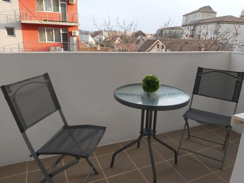 two chairs and a table on a balcony at TALINA Apartament in Oradea