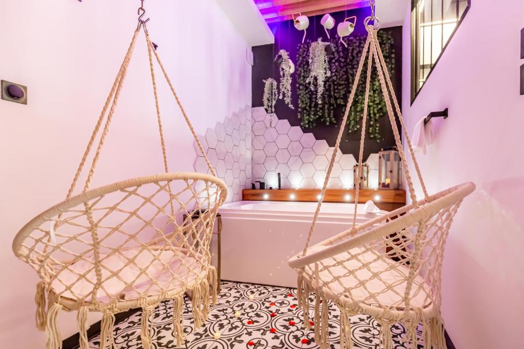 two swinging chairs in a room with a table at SWEET LEONE JACUZZI PLACE TERREAUX in Lyon