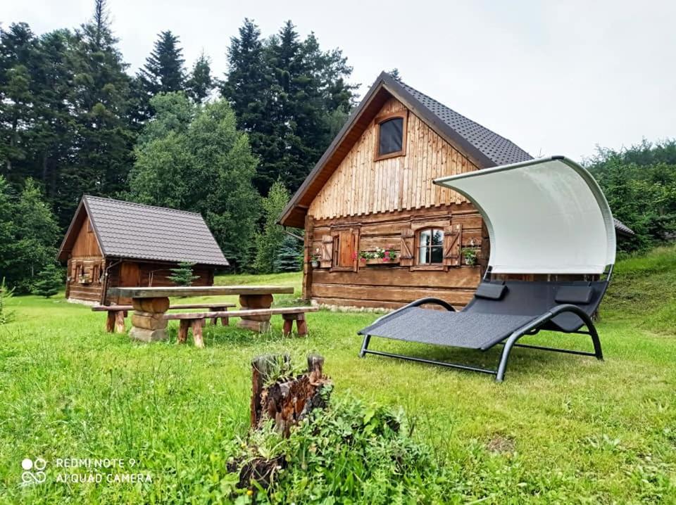 a barbecue grill in front of a log cabin at Osada Jelonki Wielka Puszcza in Porąbka