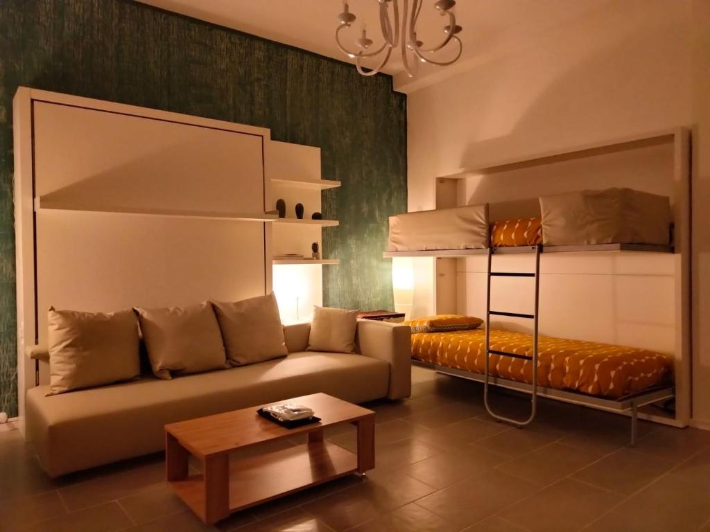 ein Wohnzimmer mit einem Sofa und Etagenbetten in der Unterkunft Arco Cutò casa vacanze in Palermo