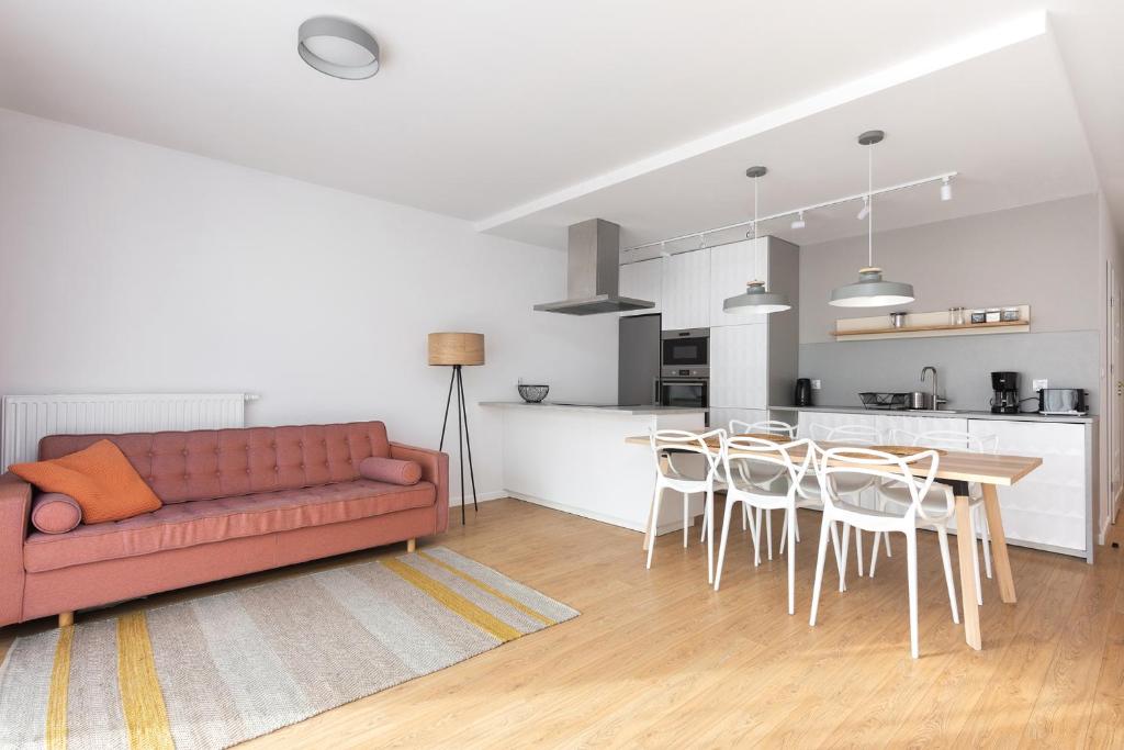 a living room with a red couch and a table and chairs at Luxury Apartment Nearto Old Town Vermelo in Krakow