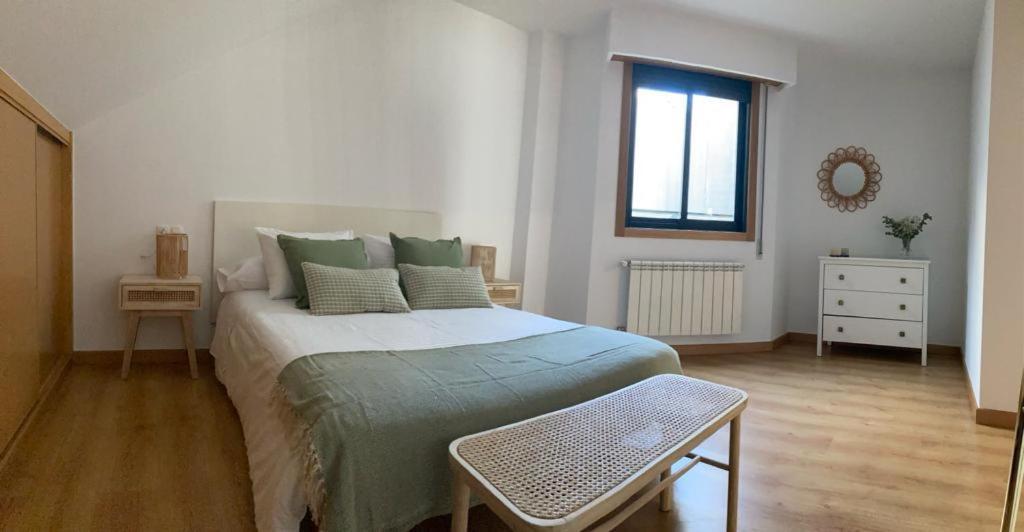 Un dormitorio con una cama grande y una ventana en O Pequeno Rincón, en Allariz
