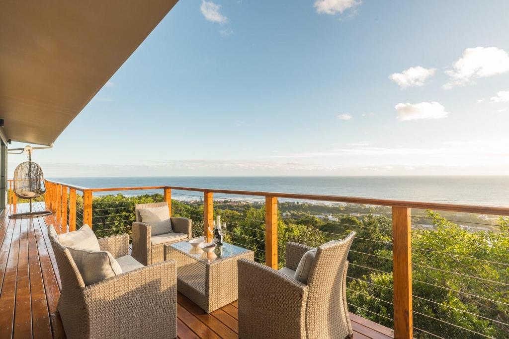 Un balcón con sillas y vistas al océano. en Constantia Views Villa Wilderness, en Wilderness