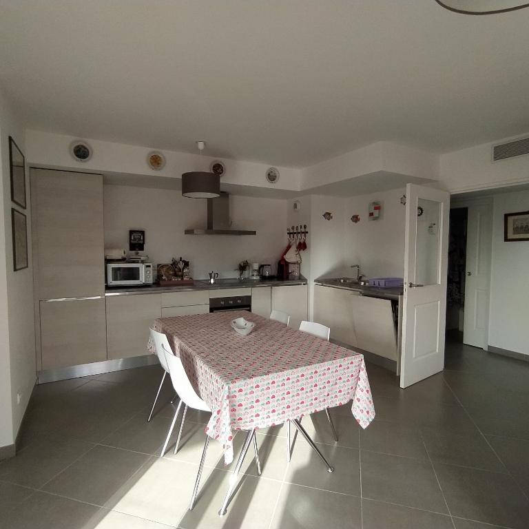une cuisine avec une table et une cuisine avec une table et des chaises dans l'établissement MENTON Park Apartment, à Menton