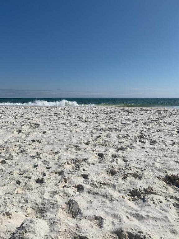 uma praia arenosa com o oceano ao fundo em 2-Bedroom Condo on Gulf Shores Beach w/Pool em Gulf Shores