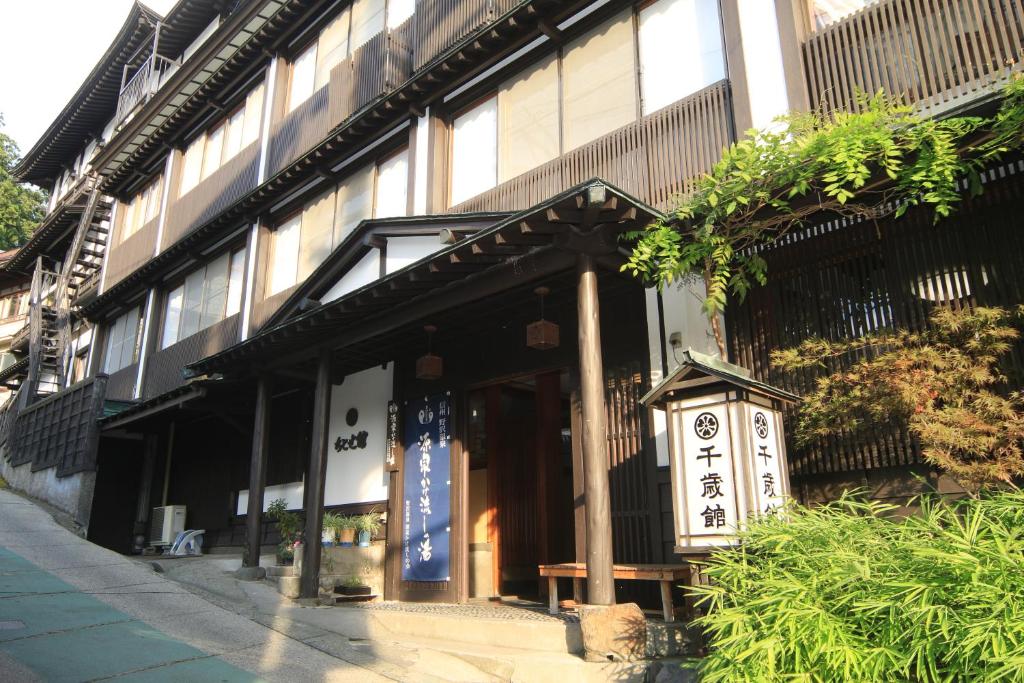 un bâtiment avec un panneau devant lui dans l'établissement Chitosekan, à Nozawa Onsen