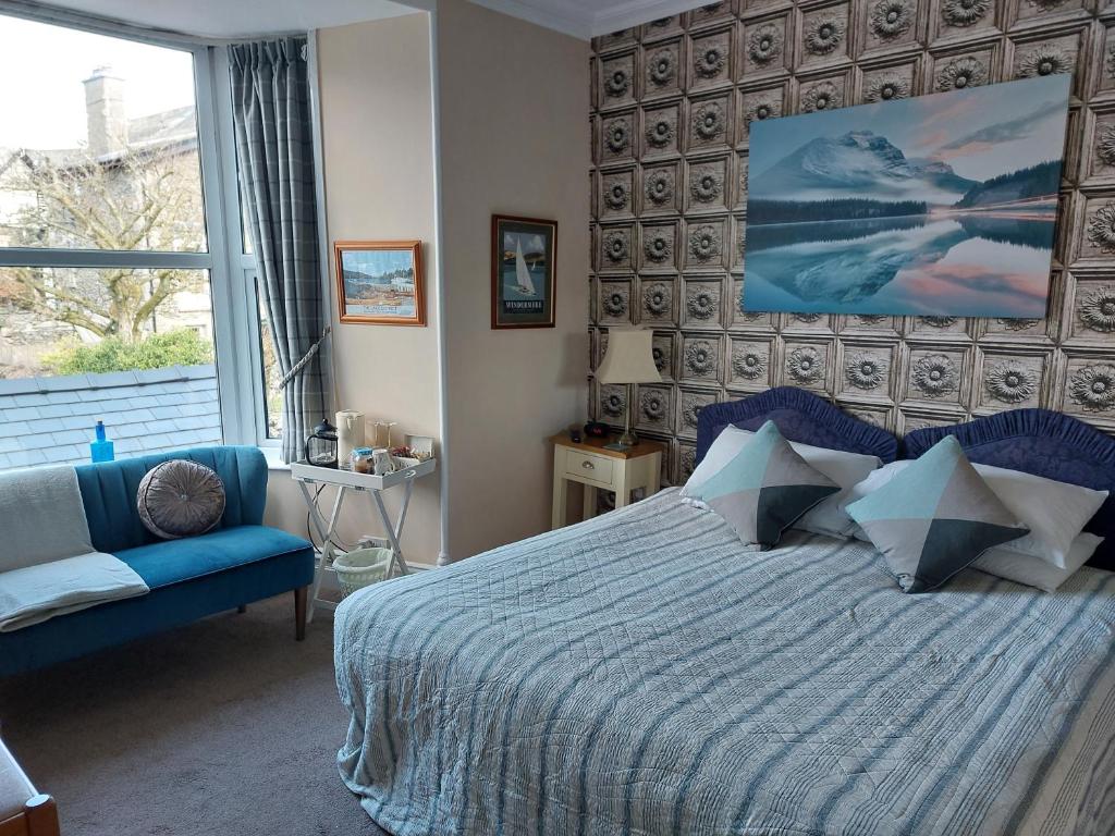 1 dormitorio con 1 cama azul y 1 sofá azul en Invergarry Room Only Guest House For Adults, en Windermere