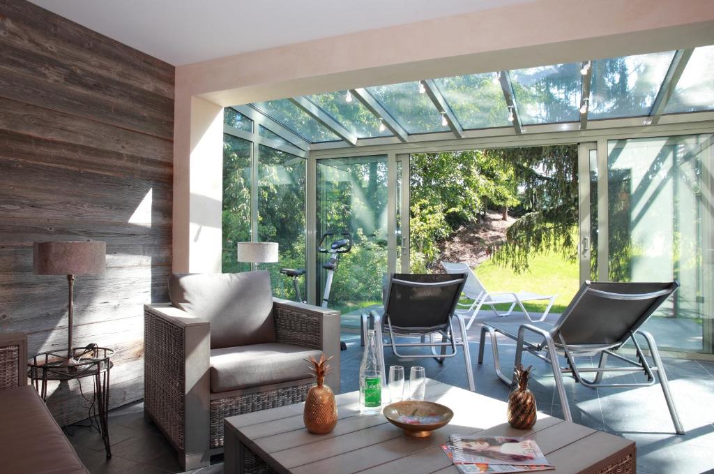 a living room with a large glass window and chairs at Hotel Restaurant L'Ami Fritz in Ottrott