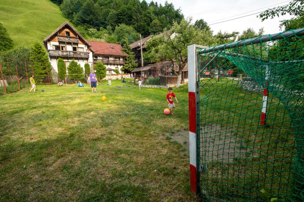 a group of children playing soccer in a yard at Pension Mama Cozonacilor in Bran