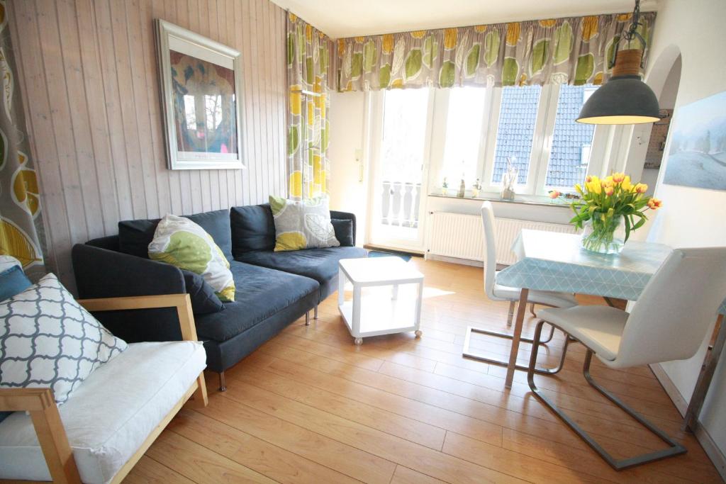 sala de estar con sofá azul y mesa en Haus Schilling, en Esens