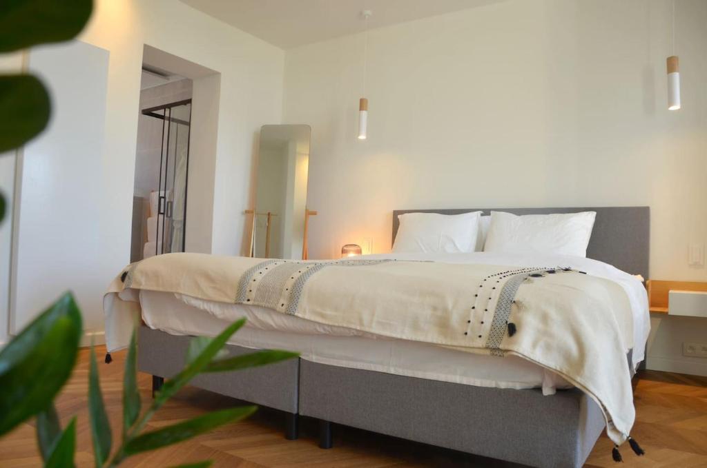 a bedroom with a large bed with white pillows at Fáilte Muur in Geraardsbergen