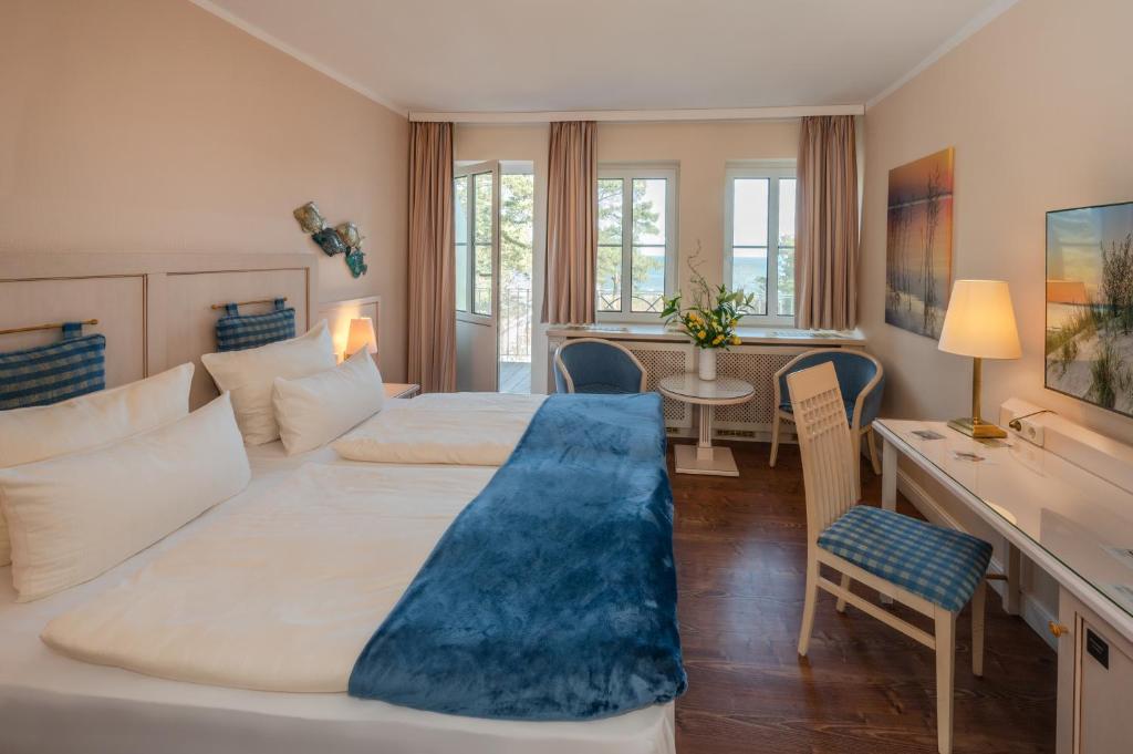 ツィノヴィッツにあるVineta Strandhotelsのベッド2台とデスクが備わるホテルルームです。