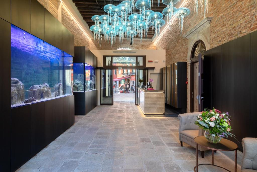 un couloir avec un lustre dans un magasin dans l'établissement Hotel Aquarius Venice-Ascend Hotel Collection, à Venise