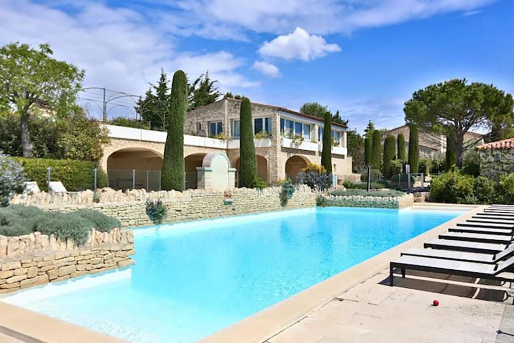 a large swimming pool in front of a house at Bastidon avec piscine Gordes Lubéron in Gordes