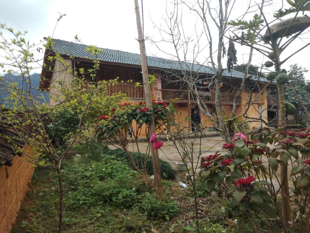 een tuin voor een huis met bloemen bij Ly Thi Chuong Homestay in Quản Bạ