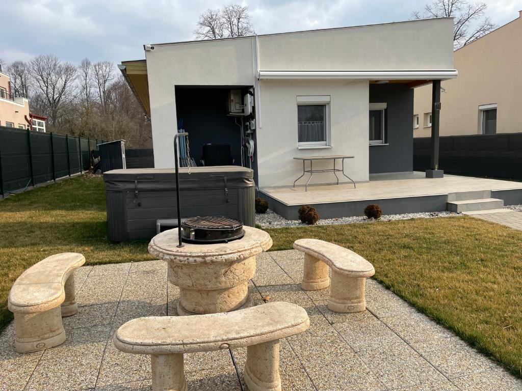 a group of benches and a grill in a backyard at Sorrento Deluxe Apartment - Jacuzzi in Siófok