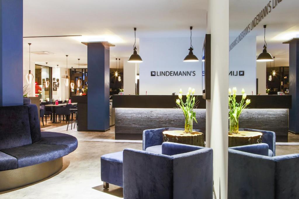 柏林的住宿－林德曼酒店，一间商店的大堂,里面摆放着蓝色的椅子和桌子