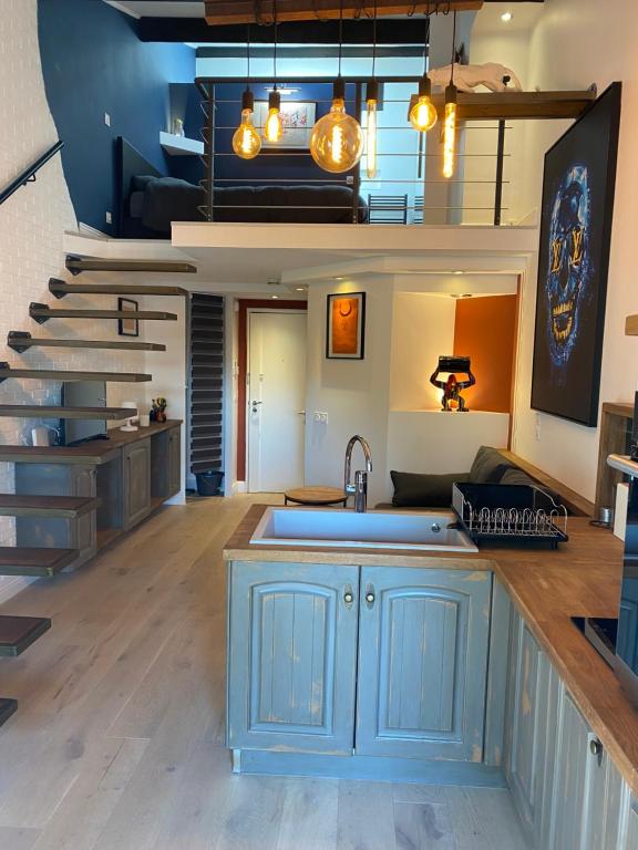 eine Küche mit blauen Schränken und einer Treppe in der Unterkunft Maison la vie est belle in Cogolin